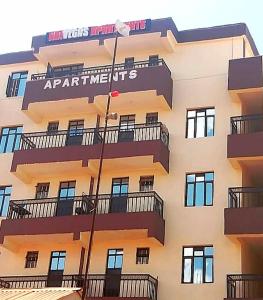 a large building with balconies on the side of it at Fan Farm Stay in Munyu