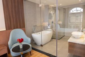 a bathroom with a tub and a glass shower at Devesun Boutique Hotel Phú Quốc in Phú Quốc +65 photos