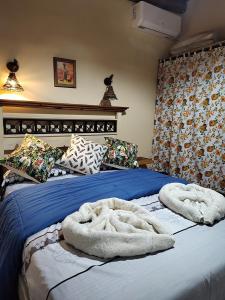 a bed with two white towels on top of it at Cabañas Mónika III Norte in Huerta Grande