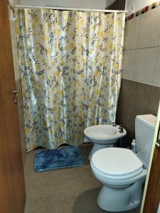 a bathroom with a toilet and a shower curtain at Cabañas Mónika III Norte in Huerta Grande
