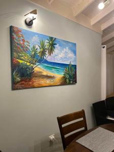 a painting of a beach with palm trees on a wall at Soulful Serenity in Steer Town