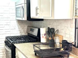 a kitchen counter with a stove top and white cabinets at Soulful Serenity in Steer Town +40 photos