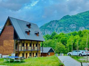 a large wooden house with a car parked next to it at Guesthouse Gjoni Theth in Theth