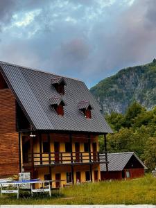 a building with a metal roof and a mountain at Guesthouse Gjoni Theth in Theth
