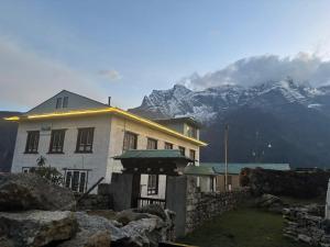 a building with a mountain in the background at Sunshine lodge in Namche