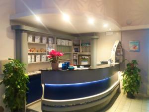 a bar in a restaurant with flowers on the counter at Hotel Meli in Castelsardo