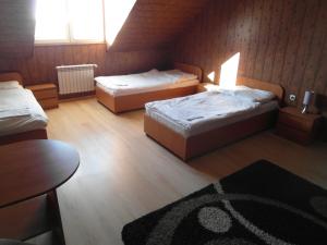a bedroom with two beds and a table and a rug at Pomorska Zajazd Restauracja in Czaplinek +20 photos