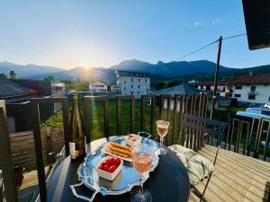 a table with glasses of wine and food on a balcony at Cocon Savoyard - Vues Alpes - 2 king size - Rando & VTT - Parking in Albertville
