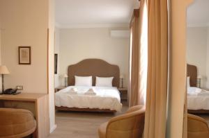 A bed or beds in a room at Hotel Hermes Tirana