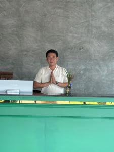 a man is sitting at a desk with his hands in hisiscopalstration at Namkhan Rivora Resort in Luang Prabang +51 photos