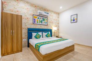 a bedroom with a bed and a wooden cabinet at Treebo Noida Business Suites in Okhla
