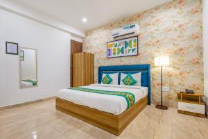 a bedroom with a king sized bed with floral wallpaper at Treebo Noida Business Suites in Okhla +32 photos
