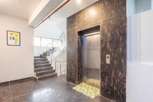 a hallway with a large stone wall and stairs at Treebo Noida Business Suites in Okhla