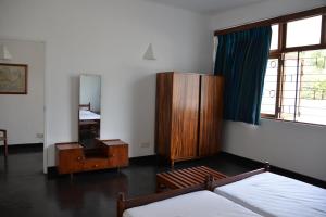 een slaapkamer met een bed, een dressoir en een spiegel bij Flower Road Apartment in Colombo