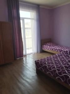 a bedroom with a bed and a large window at GuestHous LUKA in Manglisi