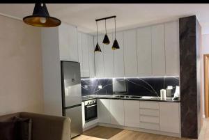 a kitchen with white cabinets and a refrigerator at Your Home Fier 2 in Fier