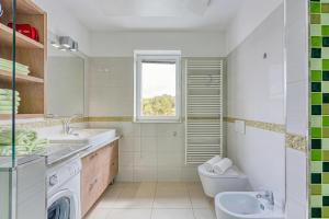 ein Badezimmer mit Waschbecken, Toilette und Fenster in der Unterkunft Debeli Rtič Apartments in Ankaran + 59 Fotos