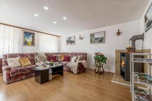 a living room with a couch and a table at Mržek House with Sauna - Happy Rentals in Nova Vas