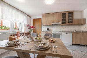 a kitchen with a wooden table with plates and silverware at Mržek House with Sauna - Happy Rentals in Nova Vas