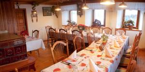 a dining room with tables and chairs with white tablecloths at Farm Pri Flandru in Cerkno