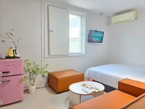 a bedroom with a bed and a table and a window at 스테이동백 in Jeonju