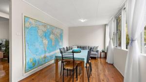 a dining room with a table and a map on the wall at Quirky and Captivating Kurra in Hawks Nest