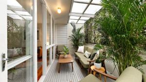 a conservatory with plants and a couch and a table at Quirky and Captivating Kurra in Hawks Nest