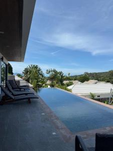 a swimming pool with lounge chairs next to a building at Villa Fiesta, 5bd, palace in Mae Nam