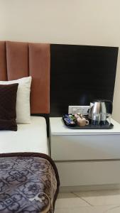 a bed with a tray with a tea pot on it at Omkar Hotel - Mahabaleshwar in Panchgani