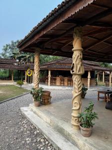 a pavilion with potted plants in front of a building at Tharu Community Lodge in Kawasoti