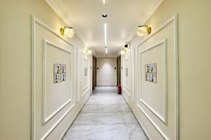 a corridor of a hallway with white walls and tile floors at Itsy Hotels Grand CG in Ahmedabad