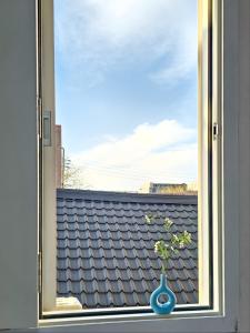 a vase on a window sill with a view of a roof at 스테이동백 in Jeonju