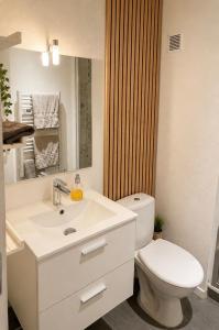 a white bathroom with a toilet and a sink at Appartement bien être à Colmar in Colmar