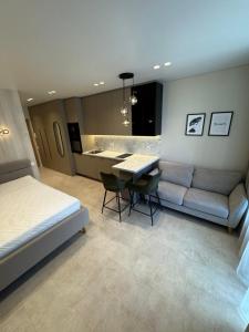 a bedroom with a bed and a table and a couch at S14 Apartment in Vilnius