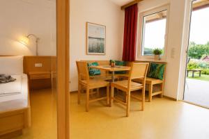 a room with a table and chairs and a bed at Ausee Lodges Blindenmarkt in Blindenmarkt