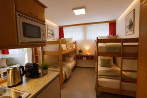 a small room with bunk beds and a kitchen at Ausee Lodges Blindenmarkt in Blindenmarkt