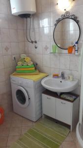 ein Badezimmer mit Waschmaschine und Waschbecken in der Unterkunft Apartments Gabriel in Nin