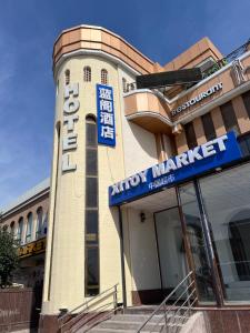 a building with a sign for a movie market at Golubie Kupola Hotel 华人酒店 in Bukhara