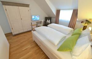 a bedroom with a bed with white sheets and green pillows at Hotel-Restaurant "Zum Alten Fritz" in Mayen