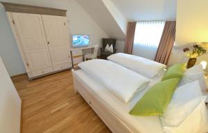 Schlafzimmer mit einem Bett mit weißer Bettwäsche und grünen Kissen in der Unterkunft Hotel-Restaurant "Zum Alten Fritz" in Mayen
