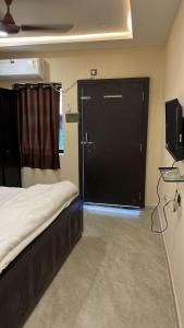 a bedroom with a large black door with a television at DownTown INN in Manendragarh