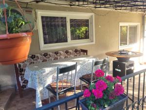 a table with chairs and flowers on a patio at Casa OPRIȚA in Hobiţa Grădişte