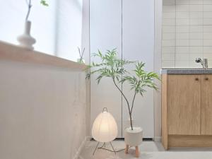 a bathroom with a vase with a plant in it at 스테이동백 in Jeonju +83 photos