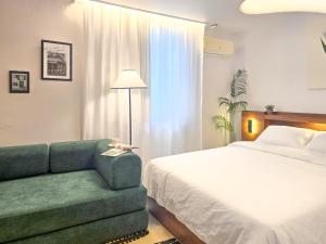 a bedroom with a bed and a green couch at 스테이동백 in Jeonju