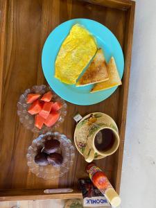 two plates of breakfast foods on a wooden tray at KUTA GLORI Homestay in Kuta Lombok +28 photos