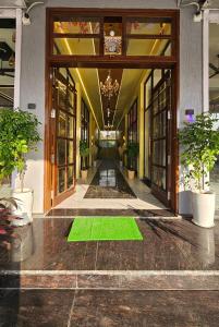 a lobby with a green rug in the middle of a building at Hotel gl palace & restaurant chomu in Jaipur