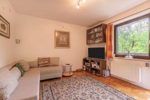 a living room with a couch and a window at House Fortin With Sauna Near Bloke Lake - Happy Rentals in Velike Bloke