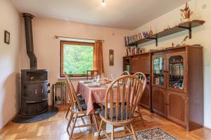 a dining room with a table and a wood stove at House Fortin With Sauna Near Bloke Lake - Happy Rentals in Velike Bloke