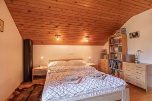 a bedroom with a bed and a wooden ceiling at House Fortin With Sauna Near Bloke Lake - Happy Rentals in Velike Bloke