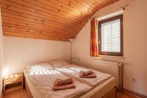 a bedroom with a bed with two pillows on it at House Fortin With Sauna Near Bloke Lake - Happy Rentals in Velike Bloke +20 photos